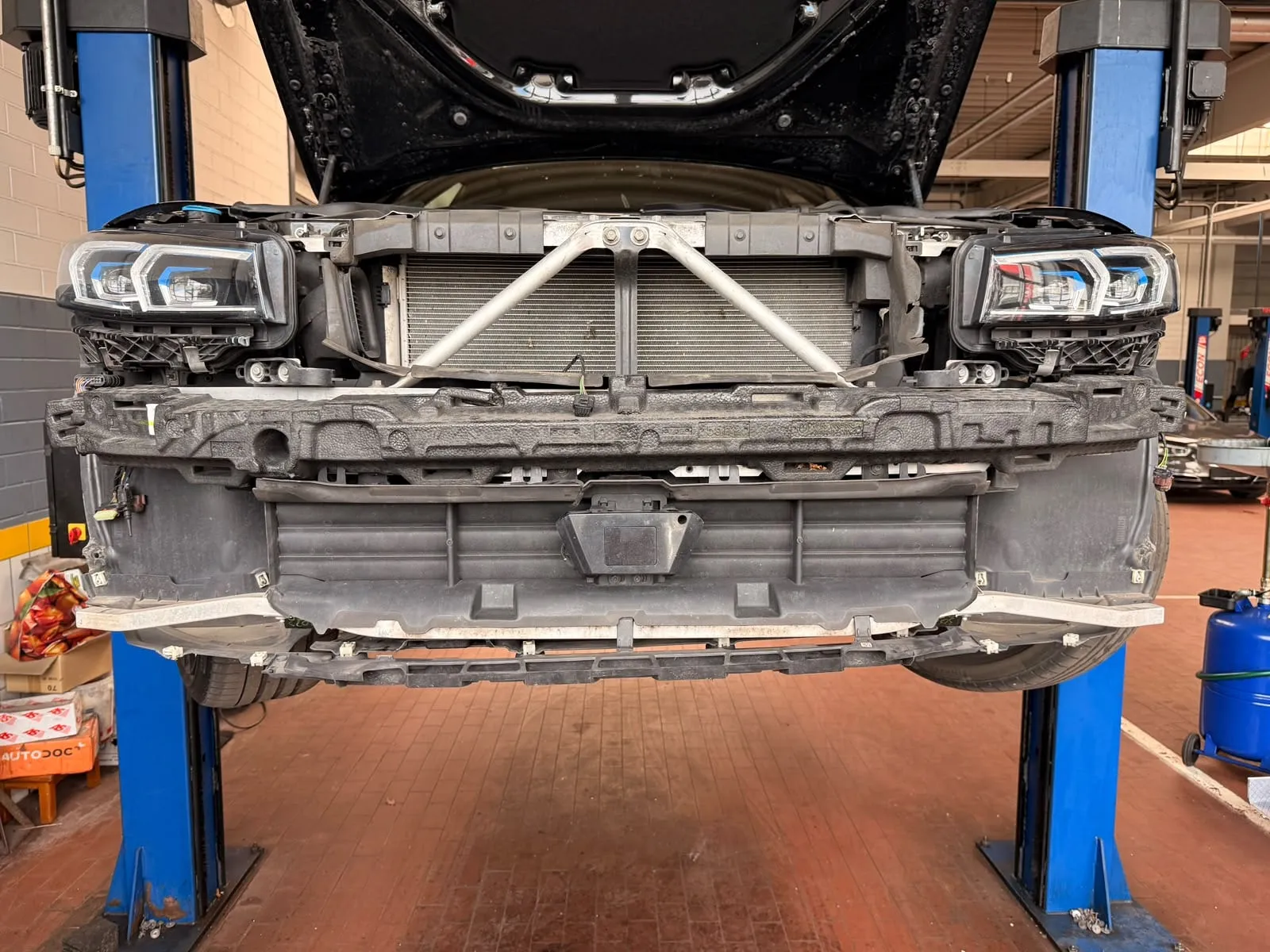 Auto ohne Frontverkleidung auf einer Hebebühne in der Werkstatt