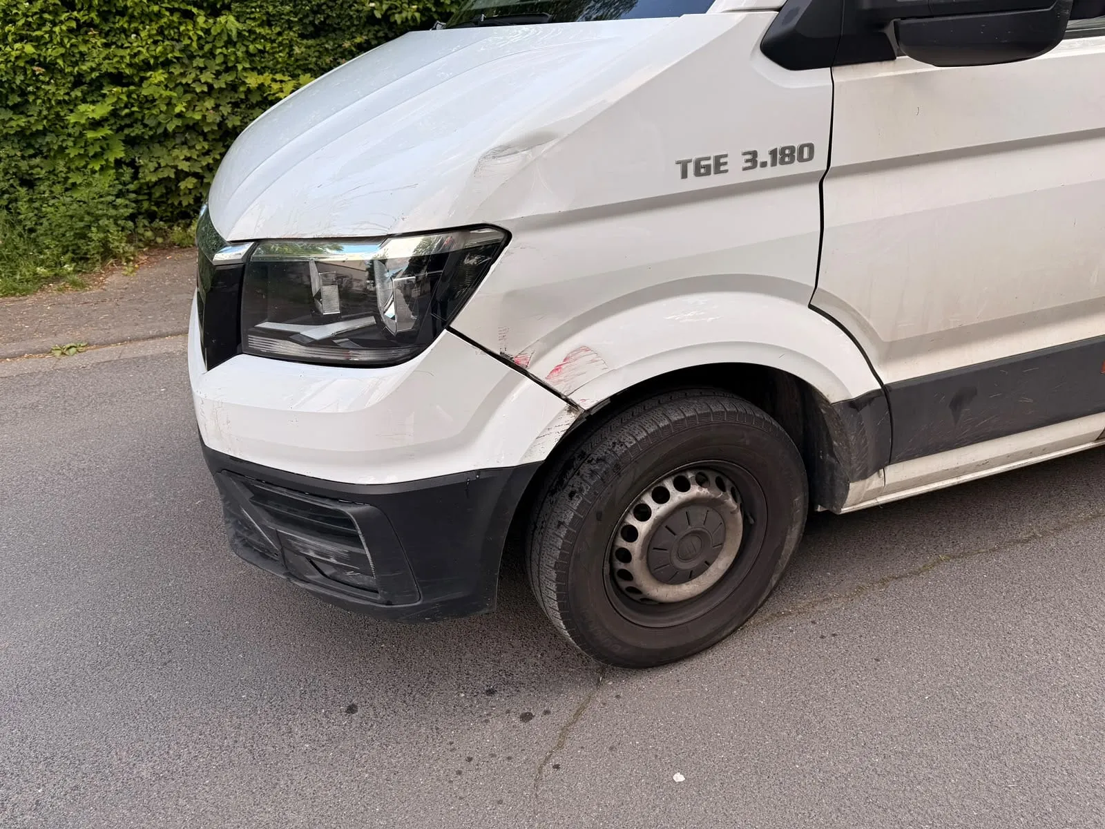 Weißer Transporter mit eingedrücktem vorderen Kotflügel