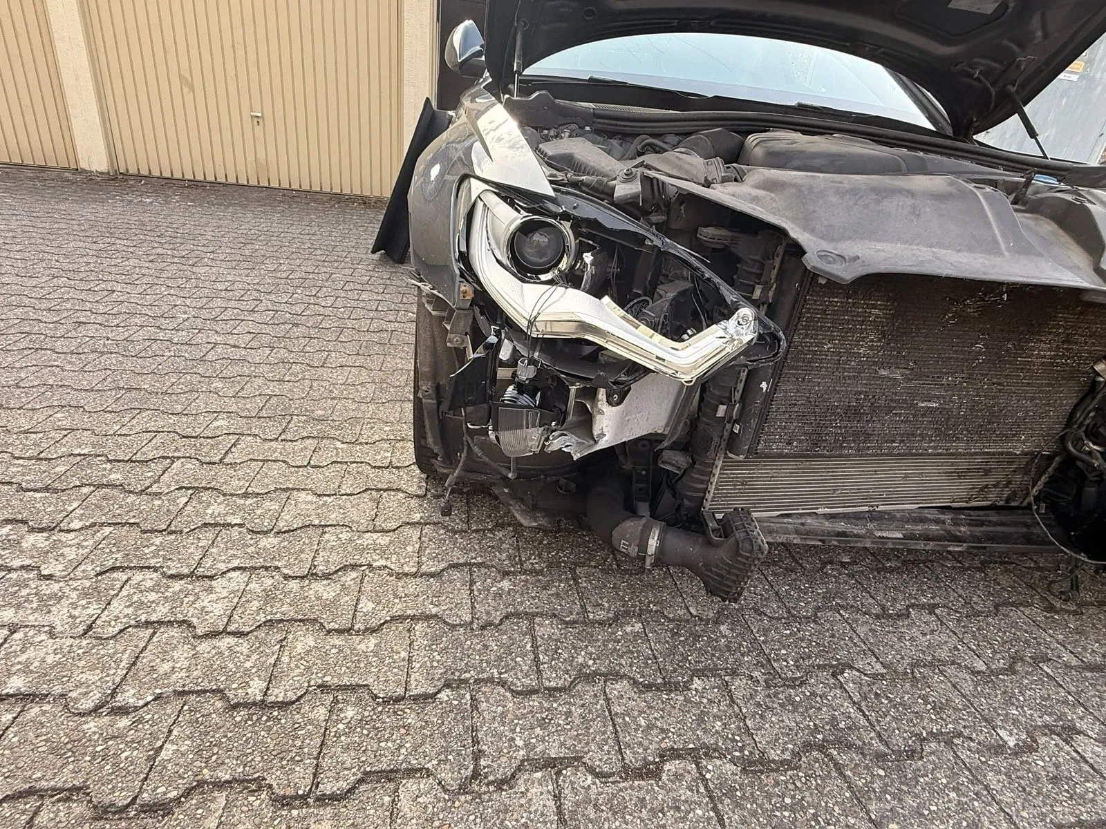 Zerstörte Front mit freiliegendem Kühler und losem Scheinwerfer